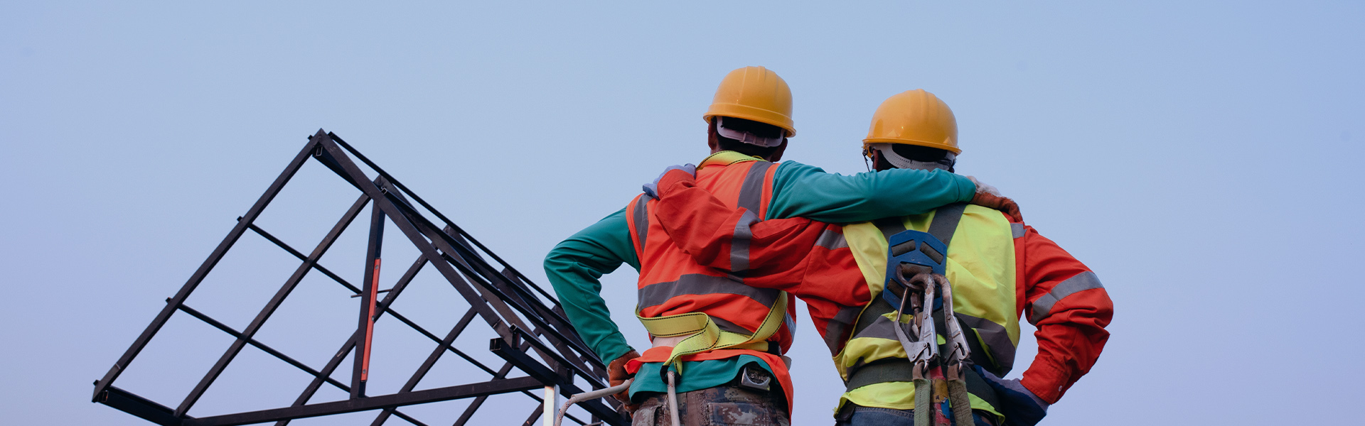 Zwei Bauarbeiter schauen zur Baustelle hinauf